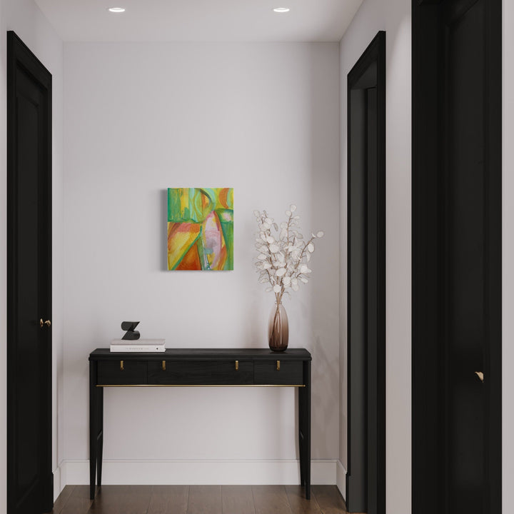 The artwork 'Half Moons' by Taiss Ghuliani features vibrant abstract oil painting displaying dynamic green and orange swirls with subtle pink undertones, mounted on a white wall above a sleek black console table. Modern interior setting showcases the 20x16 inch canvas artwork alongside decorative white florals in brown vase. Created by Taiss Ghuliani.