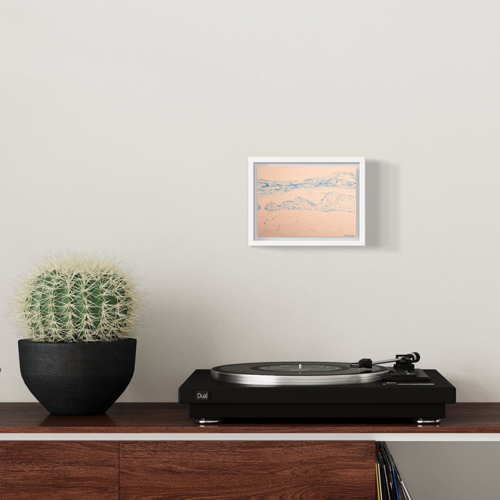 The artwork 'Drake Passage' by Ali Ha features delicate ink drawings on warm white Stonehenge paper, depicting abstract mountainous landscapes in soft peach and gray tones. The piece is elegantly presented in a crisp white frame, showcasing minimalist line work and subtle shading that captures the essence of rugged terrain. - Ali Ha