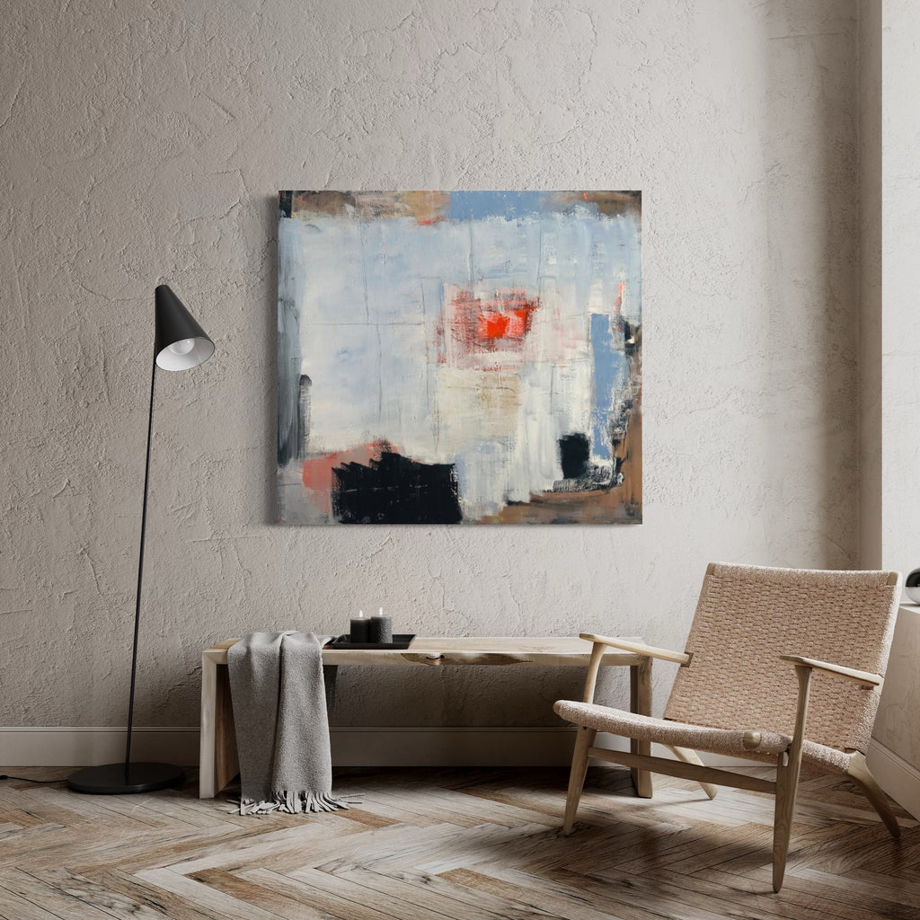 The artwork 'Meditation in an Emergency' by Petra Nimtz features abstract expressionism with bold brushstrokes of light blue, coral red, and stark black against a white background. The oil on linen painting showcases dynamic layering and textural elements, creating a sense of depth and movement. Displayed in a minimalist setting with natural textures and modern furniture.