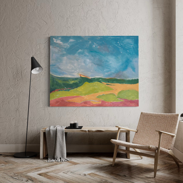 The artwork 'Colors of Autumn' by Beth Barry features a vibrant landscape painting depicting rolling hills in warm yellow and coral hues beneath a dynamic turquoise sky with sweeping brushstrokes. Abstract expressionist style acrylic on canvas captures the pastoral countryside with bold, gestural strokes and an impressionistic interpretation of nature's autumn palette. By Beth Barry.