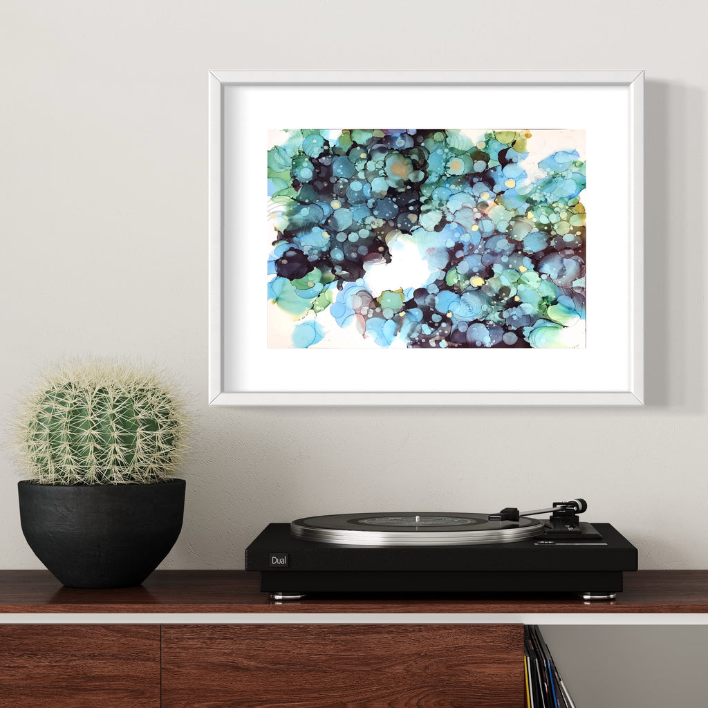 The artwork 'Minamo 6' by Sonomi Kobayashi features ethereal alcohol ink patterns on Yupo paper, creating a dreamlike aquatic effect with flowing turquoise, deep navy, and mint green bubbles. Abstract organic shapes blend and float across the surface, evoking a serene underwater landscape. The piece is elegantly presented in a white frame.