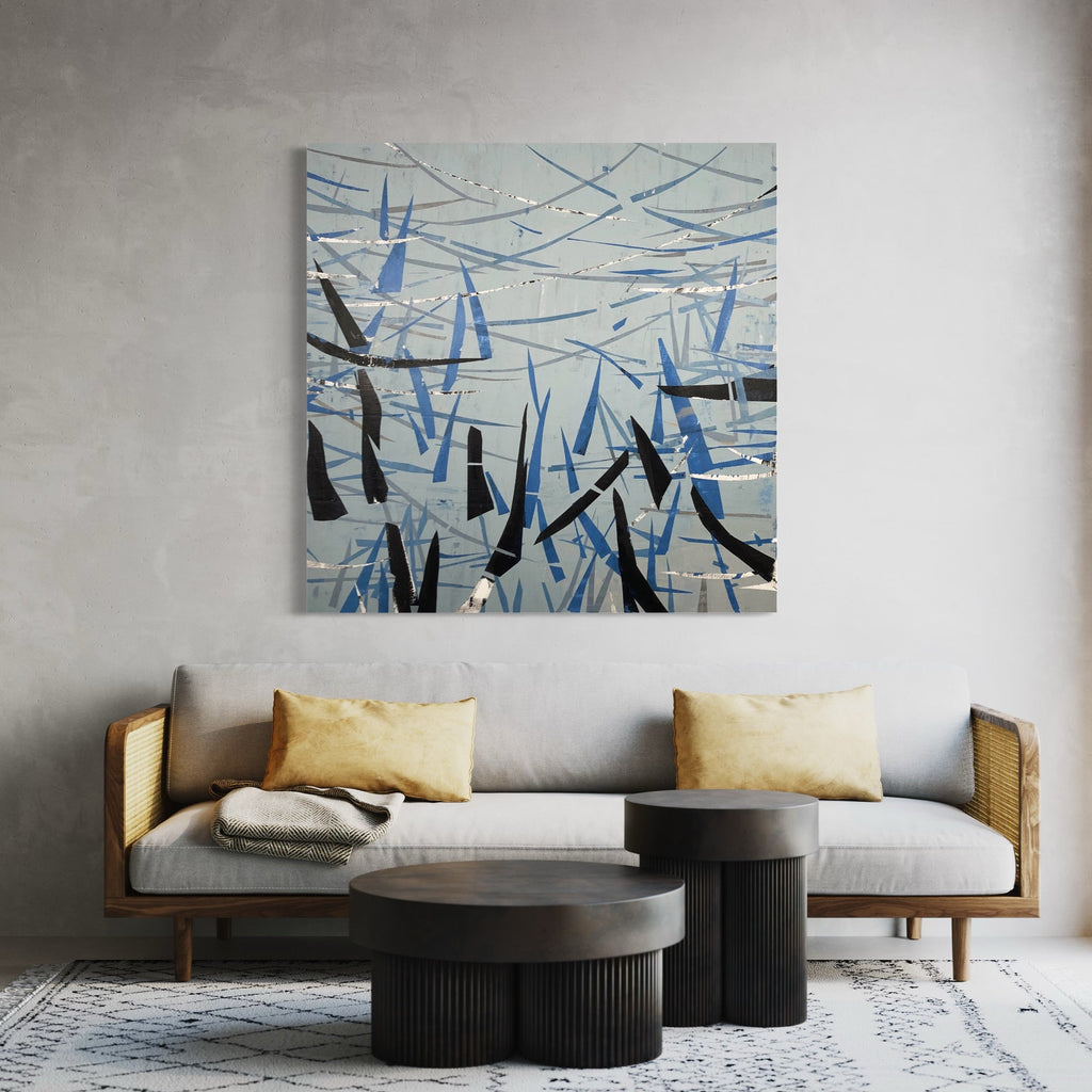 The artwork 'Northeast' by Shira Toren features an abstract composition of intersecting angular shapes in contrasting blue and black against a white background. The piece combines Venetian plaster and acrylic on canvas, creating dynamic geometric patterns reminiscent of winter branches or crystalline formations. The 50x50 inch artwork displays a sophisticated interplay of lines and negative space by Shira Toren.