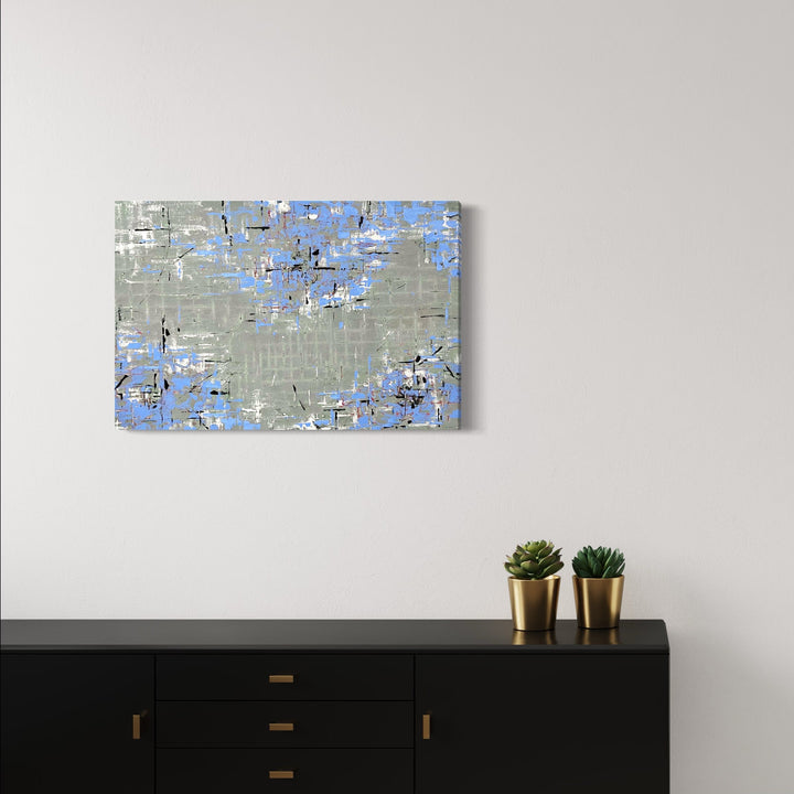 The artwork 'Gift of Blue' by Shira Toren features an abstract composition in Venetian plaster and pigment on canvas, showcasing a textured interplay of soft gray and ethereal blue tones. The 24x30 inch piece presents a weathered, layered effect with scattered blue fragments creating a sense of atmospheric depth against a muted gray background.