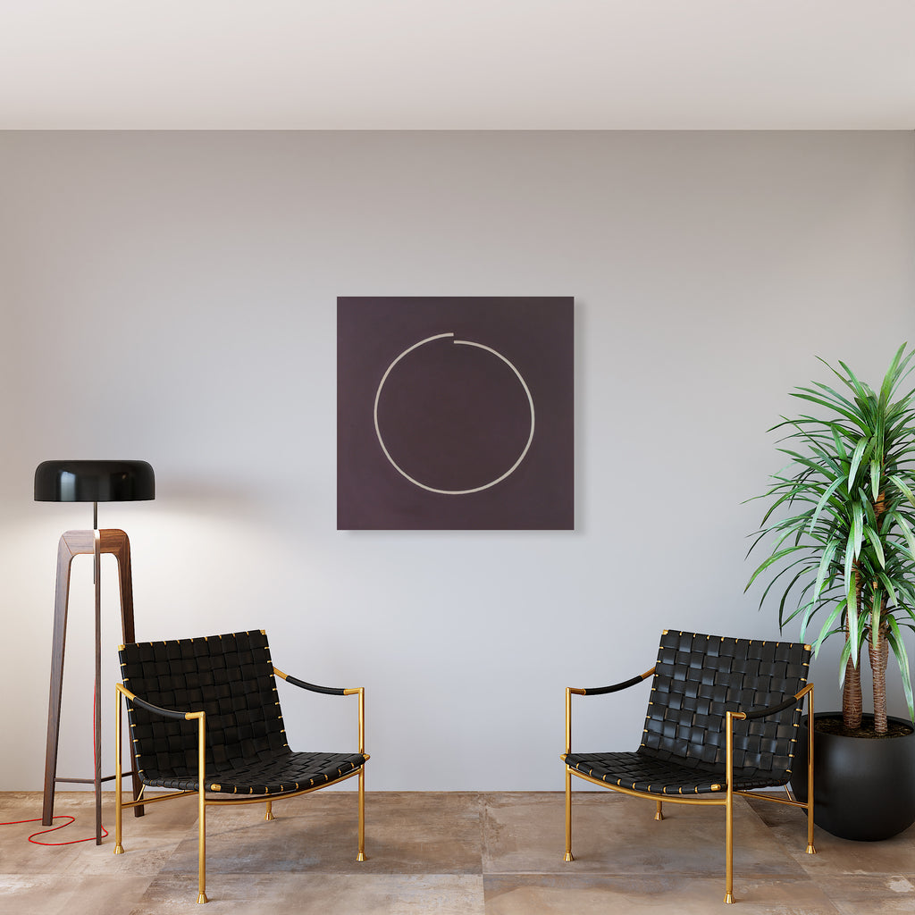 The artwork 'Leap' by Shyun Song features a minimalist design on a deep brown canvas, showcasing a delicate white circular line forming an incomplete ring. The 40x40 inch oil painting creates a striking contrast against a light gray wall, displayed above two modern black woven leather chairs with gold frames. Contemporary design aesthetic, perfect for minimalist interior spaces. By Shyun Song.