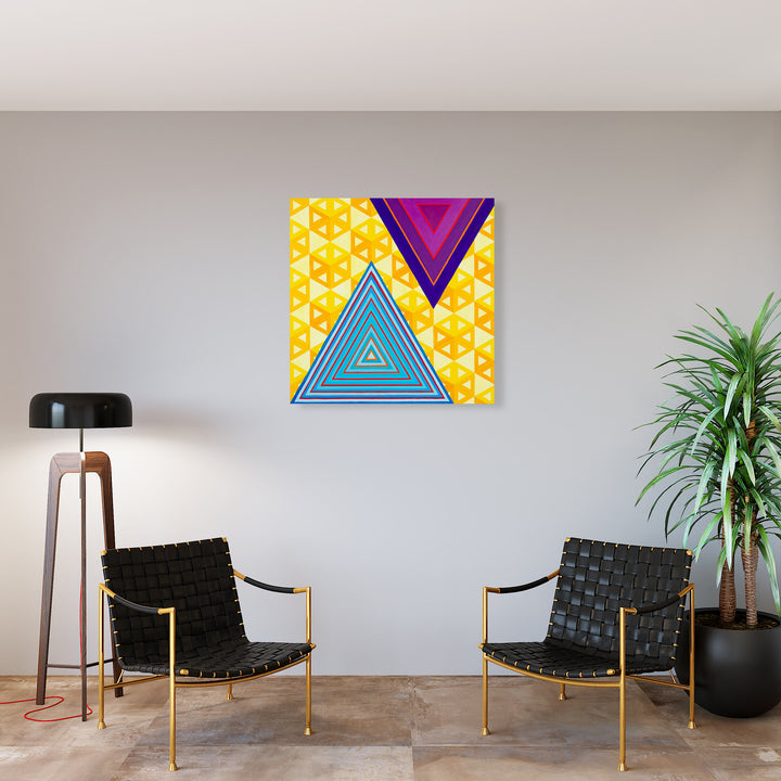 The artwork 'Ideologically Aligned but Still Afraid to Interact' by Amber Heaton features bold geometric triangles in vibrant turquoise blue and deep purple against a sunny yellow background with repeating triangular patterns. The triangles showcase concentric linear details, creating a modern, abstract composition with strong visual harmony on a 40x40 inch acrylic panel.