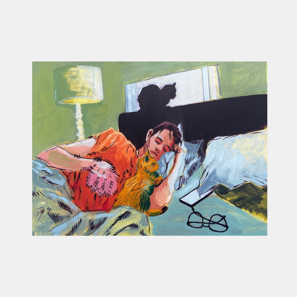 The artwork 'Matt, not feeling too hot' depicts a figure resting on a couch with a gray cat, rendered in expressive brushstrokes. A green lamp casts warm light in the background, while a second cat's silhouette perches on the sofa back. The scene features vibrant orange and yellow clothing against cool blue bedding, painted in oil and mixed media on wood. By James Kane.