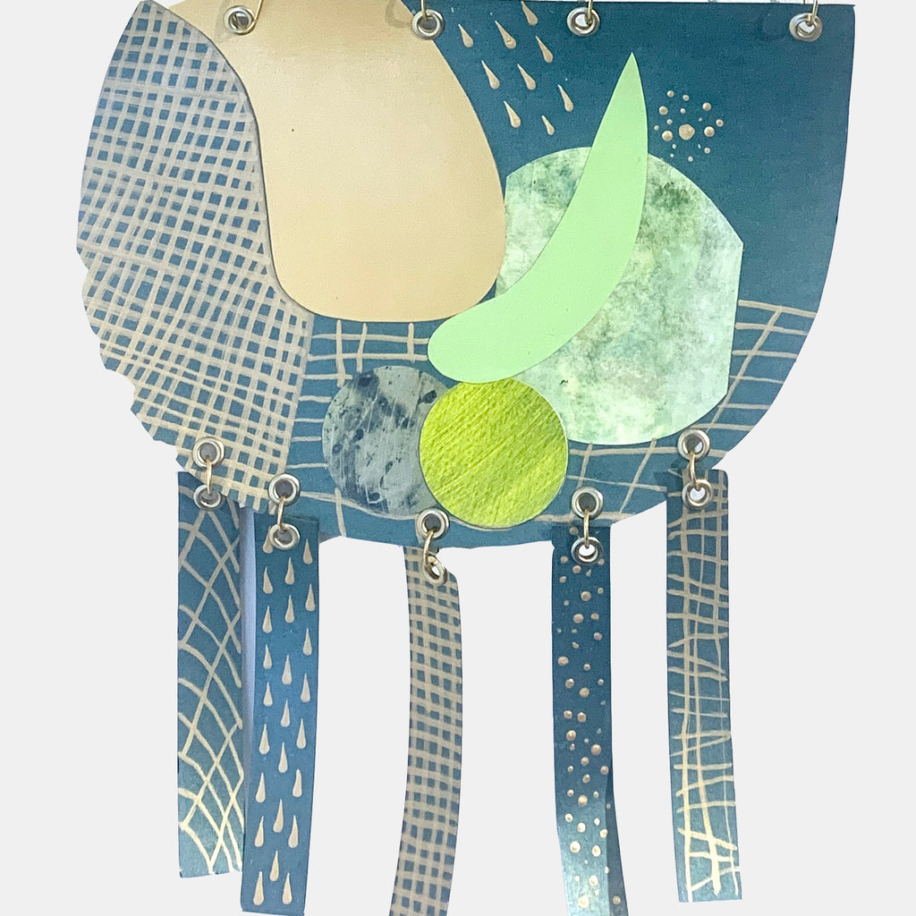 The artwork 'Juxtaposition' by Sunny Chapman features abstract geometric shapes in teal and lime green, with metallic grid patterns and circular elements. Mixed media collage combines monotype prints and textured paper, suspended by silver grommets. Layered composition creates depth through contrasting colors and patterns.