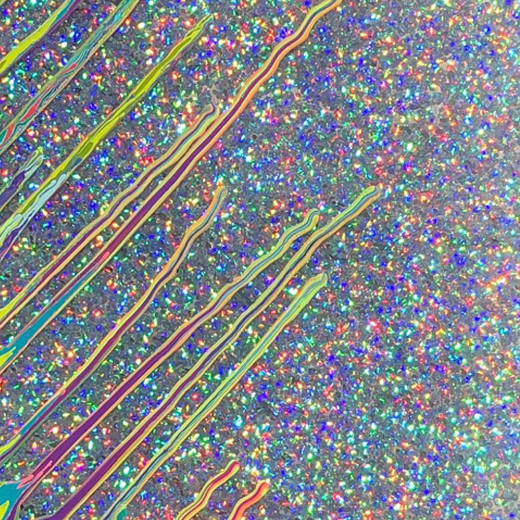 The artwork 'Kinetic e-LVI' by Paola Gracey features dynamic diagonal lines in iridescent yellows and pinks streaming across a holographic glitter background. The mixed media piece combines acrylic paint with shimmering epoxy resin, creating a mesmerizing optical effect of movement and depth against a multicolored sparkly surface that reflects blues, purples, and rainbow hues.