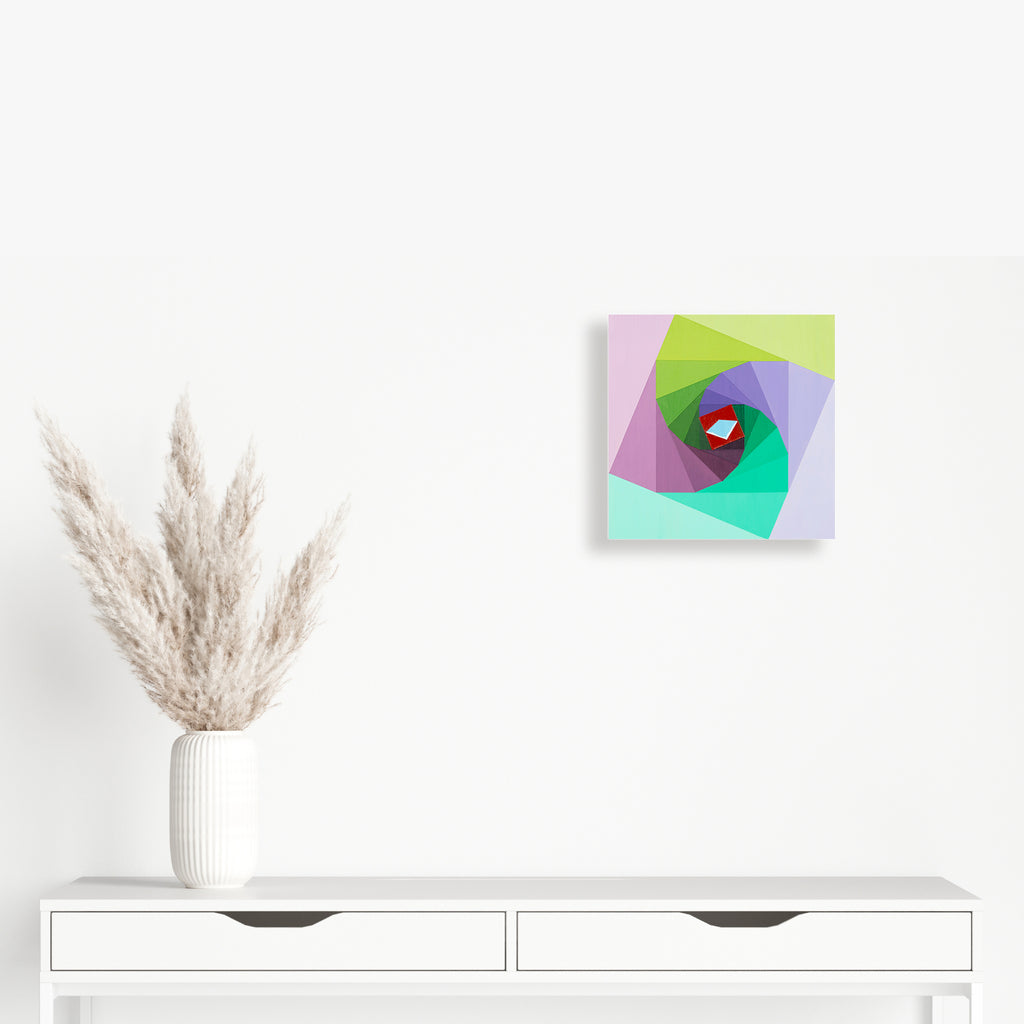 Leonardo's Octagon by Amber Heaton features a dynamic geometric composition of overlapping transparent shapes in pastel colors. The 12x12 inch acrylic panel artwork creates a spiral effect through layered polygons in mint green, soft pink, lavender, and lime, converging towards a striking red diamond center point.