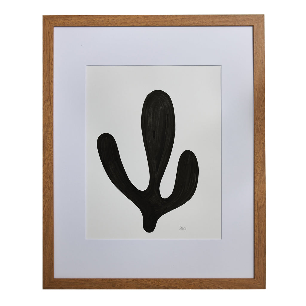The artwork 'Morning Meditation II' by Shadia Sabagh features a bold, minimalist black organic form against a white background. The abstract shape resembles a simplified cactus or plant silhouette with three rounded extensions, rendered in acrylic marker. The piece is elegantly presented in a wooden frame with white matting, creating a striking monochromatic composition.