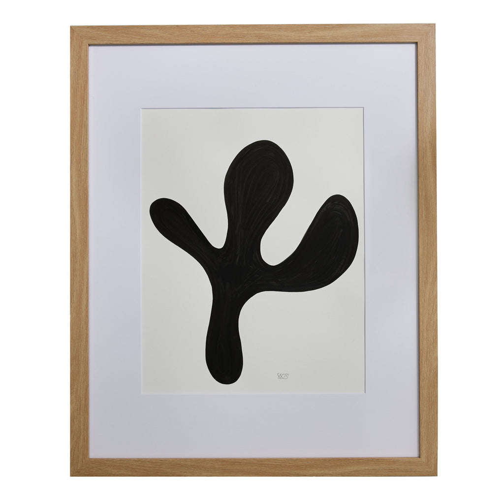 The artwork 'Morning Meditation XI' by Shadia Sabagh features a bold black organic shape against a white background, resembling an abstract botanical form with curved extensions. The minimalist composition in acrylic marker displays a fluid, biomorphic design framed in light wood, creating a striking monochromatic contrast.