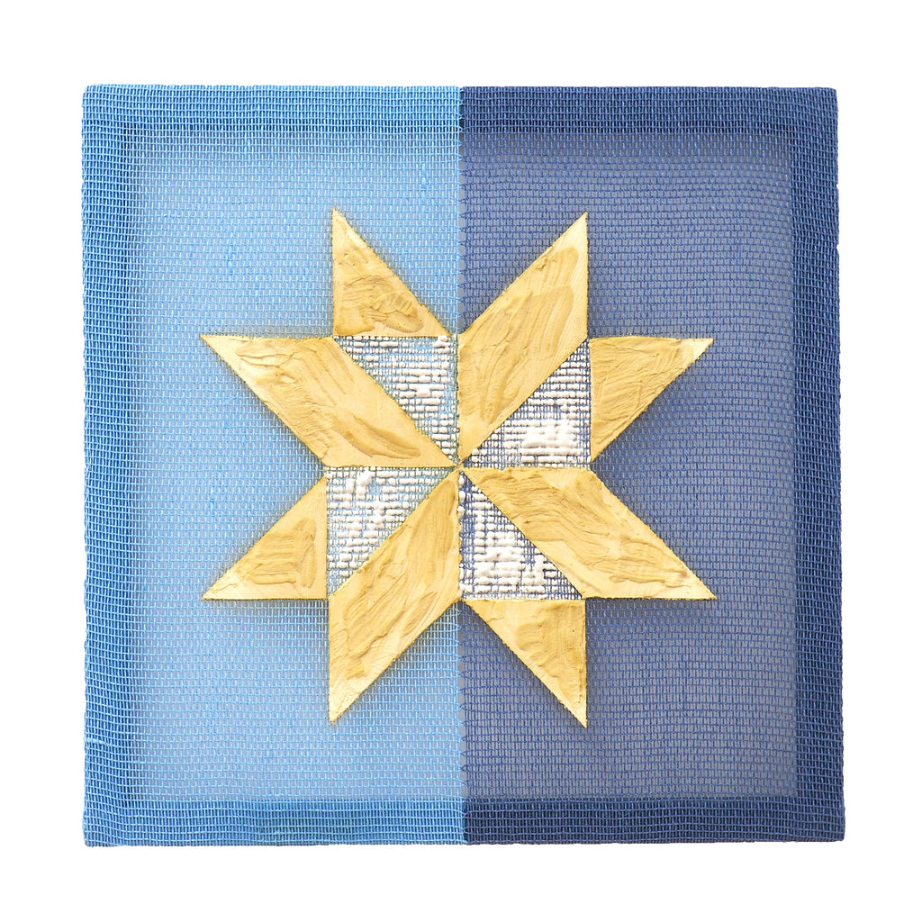 The artwork 'Memory' by Morgan Hale features a geometric eight-pointed star in golden plaster against a split-tone blue handwoven linen background. The textured star motif contains subtle newsprint patterns, while the linen canvas transitions from light to navy blue in a symmetrical gradient, creating a striking contrast with the dimensional star element.