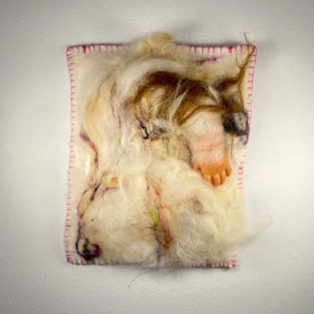 The artwork 'Miniature II' by María Antonia Villaseñor-Marchal features a textural fiber art composition with cream-colored wool, alpaca, and bison fibers. Abstract forms emerge from layered materials on a rectangular base with pink blanket stitching. A pale flesh-toned doll arm element adds sculptural dimension. The piece measures 9x7 inches with delicate thread details and organic movement throughout.