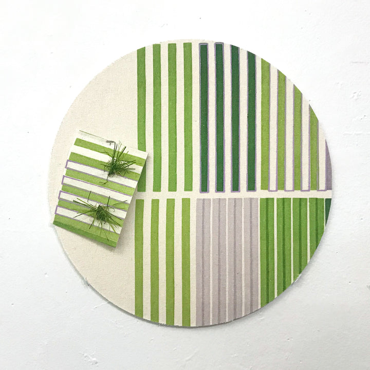 The artwork 'Line Study 4' by Molly Koehn features a circular composition with parallel vertical stripes in varying shades of green and gray. A small square element with matching stripes and artificial turf texture sits in the upper left quadrant. Created using pigment and astroturf on raw silk mounted to birch, the piece presents a minimalist geometric study in color and texture.