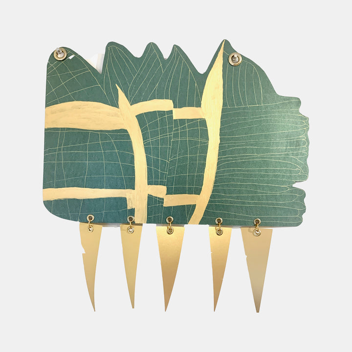 The artwork 'Mountain Roads' by Sunny Chapman features an abstract geometric design combining dark green and metallic gold elements. Intersecting linear patterns create a mountainous landscape effect on premium metallic paper, enhanced with hand-drawn details in gel pen and secured with brass grommets, forming a contemporary mixed-media composition.