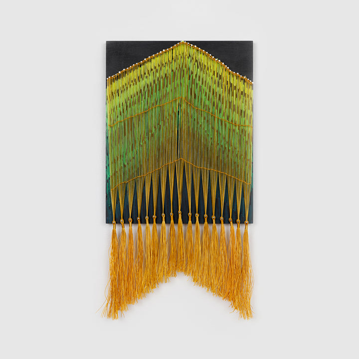 The artwork 'Night Forest' by Amber Heaton features a striking geometric pattern of vertical lines and tassels, transitioning from deep green to vibrant yellow. The piece combines acrylic paint on wood with hanging cord elements, culminating in golden fringe tassels that create a cascading forest-like effect. The contemporary wall hanging measures 22x12 inches and blends structured design with fluid movement.