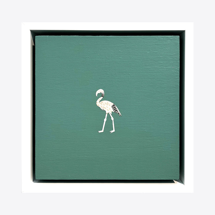 The artwork 'Profit Margins, Flamingo' by Jacki Davis features a minimalist white flamingo silhouette crafted from US currency on a teal-green wooden panel. The bird stands elegantly centered against the solid background, creating a striking contrast in an 8x8 inch contemporary mixed media composition.