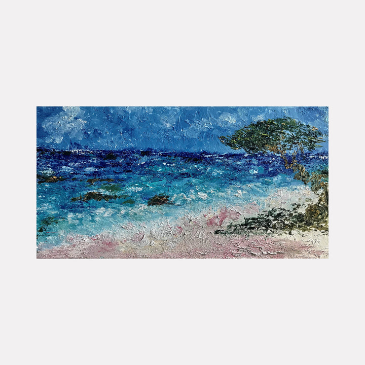 The artwork 'The Time Off' by Rita BasuMallick features a vibrant seascape with textured oil strokes depicting turquoise waters meeting a pink sandy beach. A solitary wind-swept tree stands against a deep blue sky, while rocky outcrops emerge from the ocean. The impasto technique creates a dynamic, three-dimensional surface capturing the coastal atmosphere.