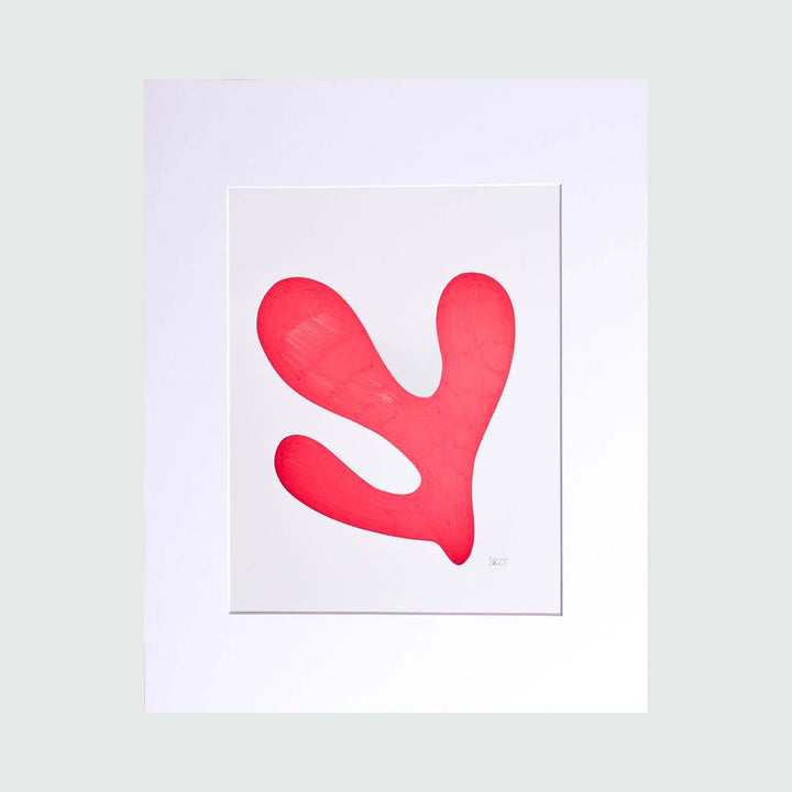The Morning Meditation Series 3 by Shadia Sabagh features a vibrant coral-red organic shape against a crisp white background. The freehand drawing depicts a fluid, abstract form resembling a curved branch or flowing water, rendered in smooth, continuous lines. The minimalist limited edition print showcases a bold, contemporary aesthetic in a 20x16 inch format with a clean matted presentation.