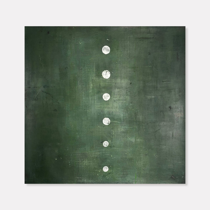 The artwork 'Green Stone' by Shira Toren features a minimalist composition with six white circular forms arranged vertically against a deep forest green background. The textured Venetian plaster surface creates subtle variations in the emerald tones, while the luminous white circles appear like ascending moons or stepping stones against the moody, atmospheric canvas.