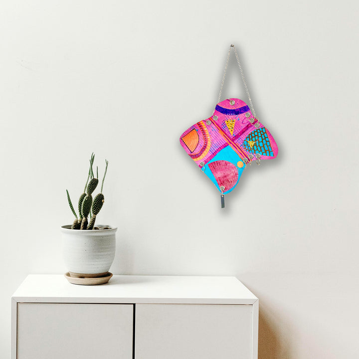 Petite Quartet by Sunny Chapman features a vibrant abstract composition with geometric patterns in hot pink, turquoise blue, and orange. The 12x12 inch acrylic painting on paper displays curved lines and bold shapes arranged in four quadrants, creating a dynamic and playful modern art piece. Mounted on a white wall, the artwork showcases energetic color combinations and rhythmic design elements.