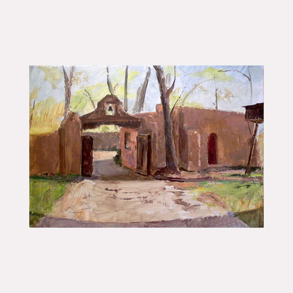 The artwork 'Mabel Luhan Dodge House, Taos, NM' depicts an adobe-style entrance gate with traditional southwestern architecture, featuring earthen walls and an arched gateway. Soft spring light illuminates bare trees against a pale sky, with dusty path leading to entrance. Oil on panel by Peter Colquhoun.