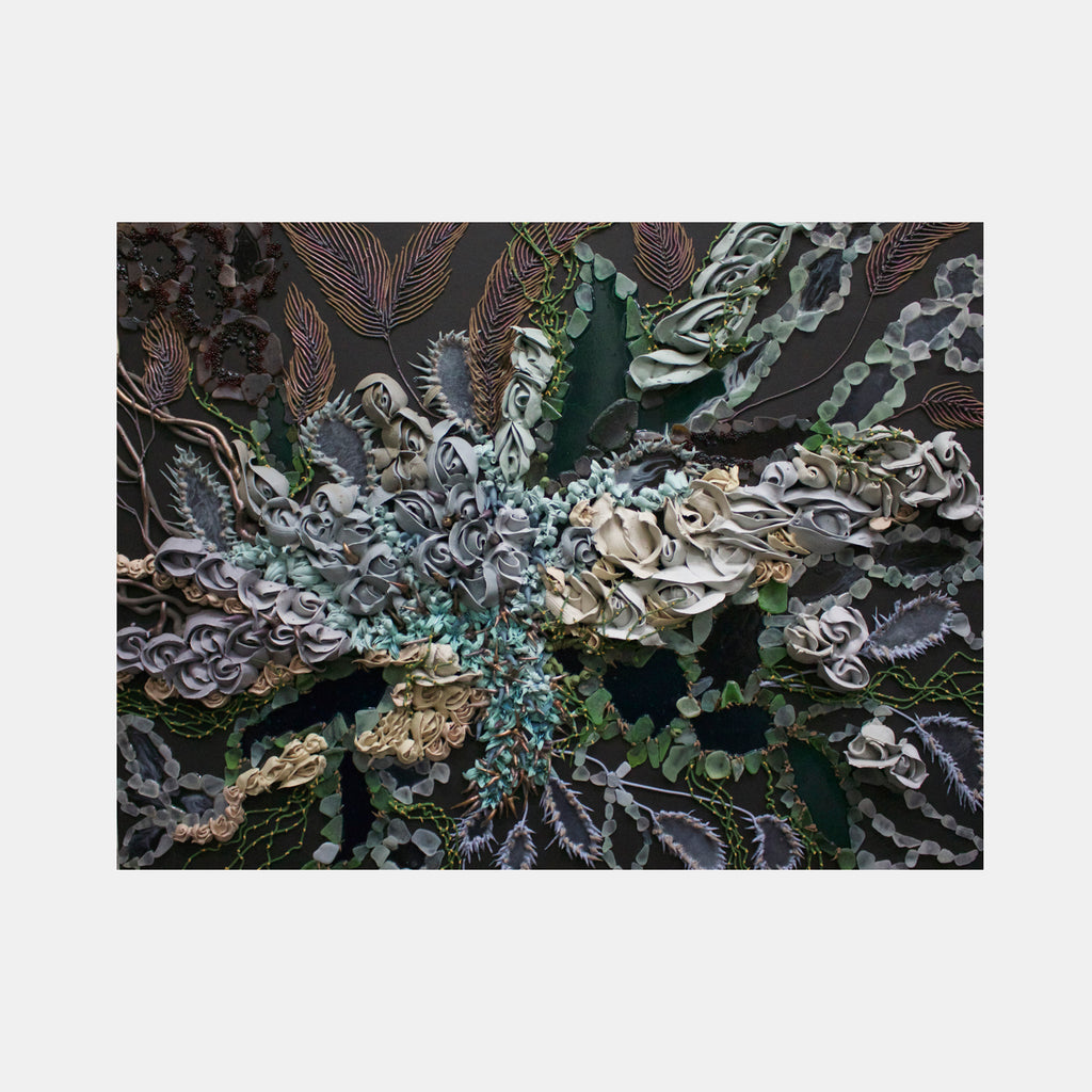 The artwork 'Primordial Arabesque' features swirling, organic patterns in seafoam green, silver, and deep charcoal tones. Textured with glass beads and beach glass, the piece creates a dynamic vortex effect with flowing, feather-like shapes radiating from a central point. The mixed media artwork combines glossy and matte finishes in an abstract marine-inspired composition by Seren Morey.