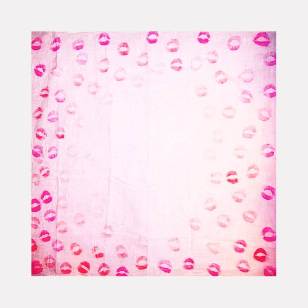 The artwork 'Sealed with a kiss 3' by Ronit Levin Delgado features multiple pink and red lipstick impressions arranged in a border pattern on a light pink canvas. The kiss marks create a frame-like effect around a softer central area, showing various shades and intensities of lip prints on the 10x10 inch surface.