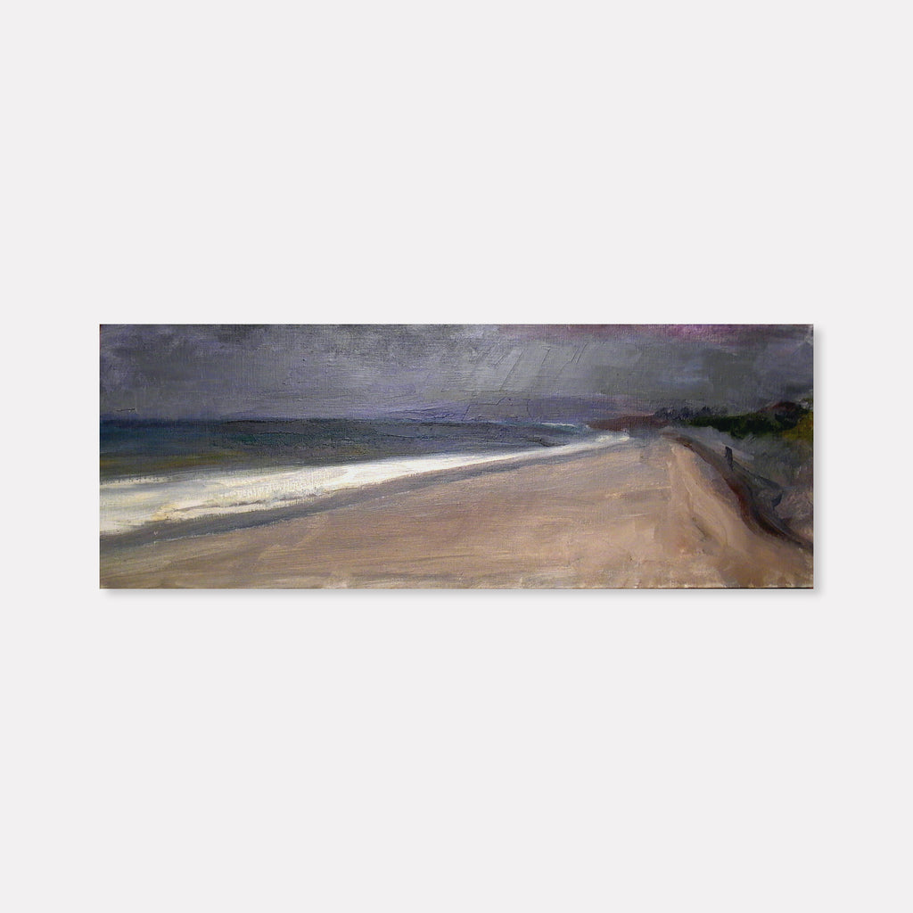 The artwork 'Sandy Hook' by Peter Colquhoun depicts a moody coastal landscape with a sweeping sandy beach curving into the distance. Dark storm clouds loom overhead, creating dramatic contrast with the pale sand and white surf. The oil on linen painting captures the raw beauty of the shoreline using muted greys, tans, and deep blues.