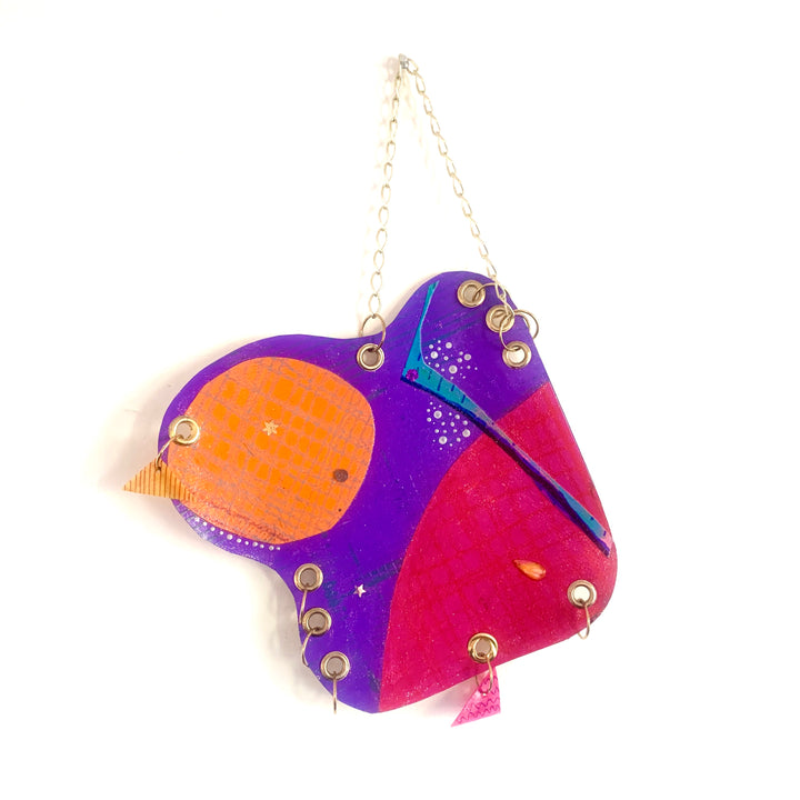 The artwork 'Satellite' by Sunny Chapman features an abstract celestial design in vibrant purple, hot pink, and orange acrylic on paper. The 12x12 inch piece displays whimsical curved shapes interconnected with metallic gold accents and delicate turquoise details, creating a playful cosmic composition resembling a stylized satellite or celestial body.
