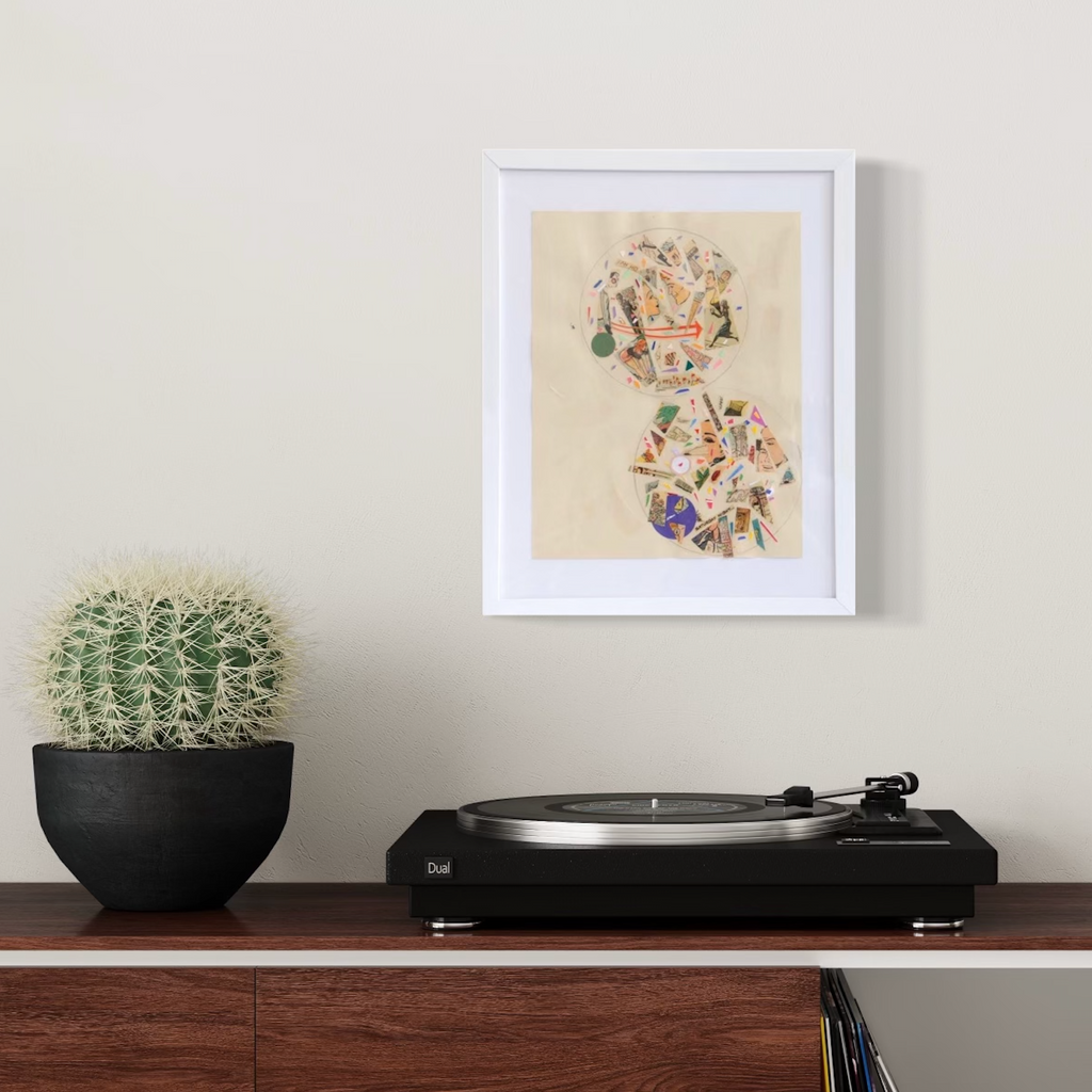 The artwork 'Optical Processing B' by Travis Witmer features two circular collage compositions on cream-colored paper. Each circle contains layered fragments of vintage papers, playing cards, and geometric shapes arranged in a dynamic, kaleidoscopic pattern. The upper circle showcases warm orange tones, while the lower circle incorporates deep purple accents, all displayed in a clean white frame. Created by Travis Witmer.