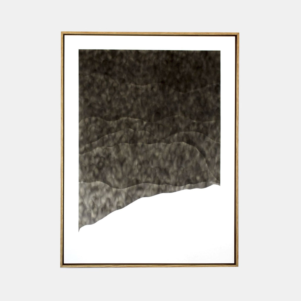 The artwork 'Slew-Footed' by Evan Ishmael features a dramatic monochromatic composition created with soot on panel. The piece showcases an abstract landscape-like form with varying gradients of charcoal gray tones, transitioning from deep black at the top to lighter shades below, creating a textured, misty effect against a stark white background. The irregular bottom edge suggests a mountain slope or geological formation.