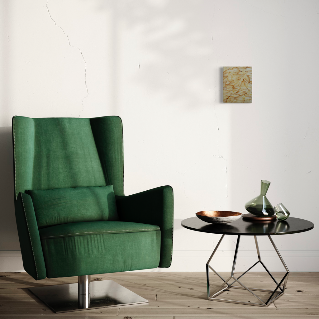 The artwork 'Deflorees Origins Tulip 04' by Valerie Hallier features an elegant minimalist interior setting with a contemporary emerald green velvet wingback chair, positioned beside a modern round black side table with geometric metal base. Wall art with organic beige patterns visible in background. High-end furniture photography composition.