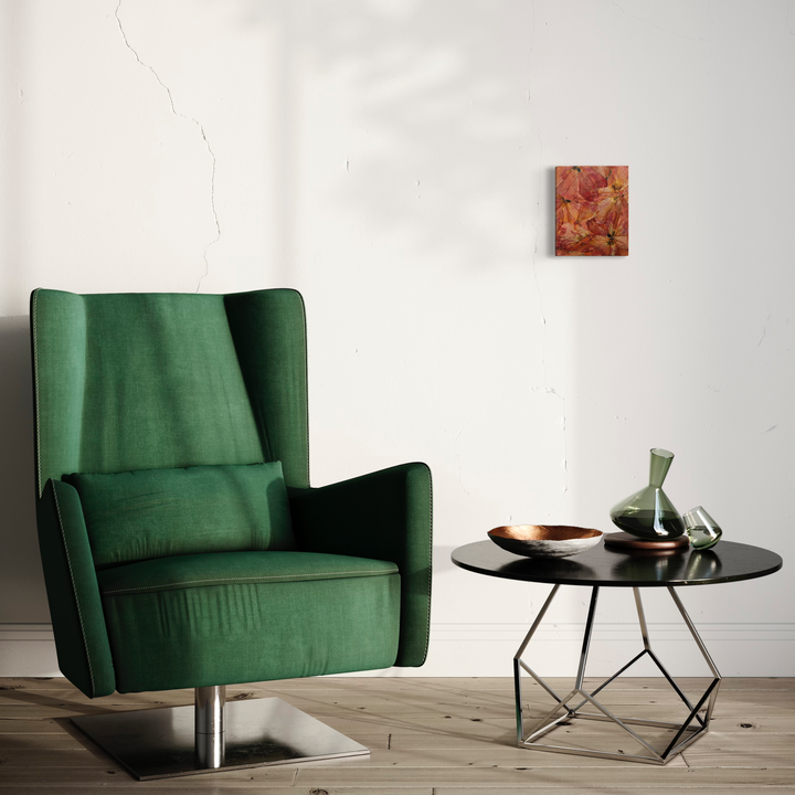 The artwork 'Deflorees Origins Tulip 05' by Valerie Hallier displayed in a modern interior setting with emerald green velvet wingback chair. Abstract floral composition in coral and pink tones mounted on small canvas, showcasing preserved tulip petals sealed in polyurethane varnish. Wall art captures organic textures and natural patterns by Valerie Hallier.