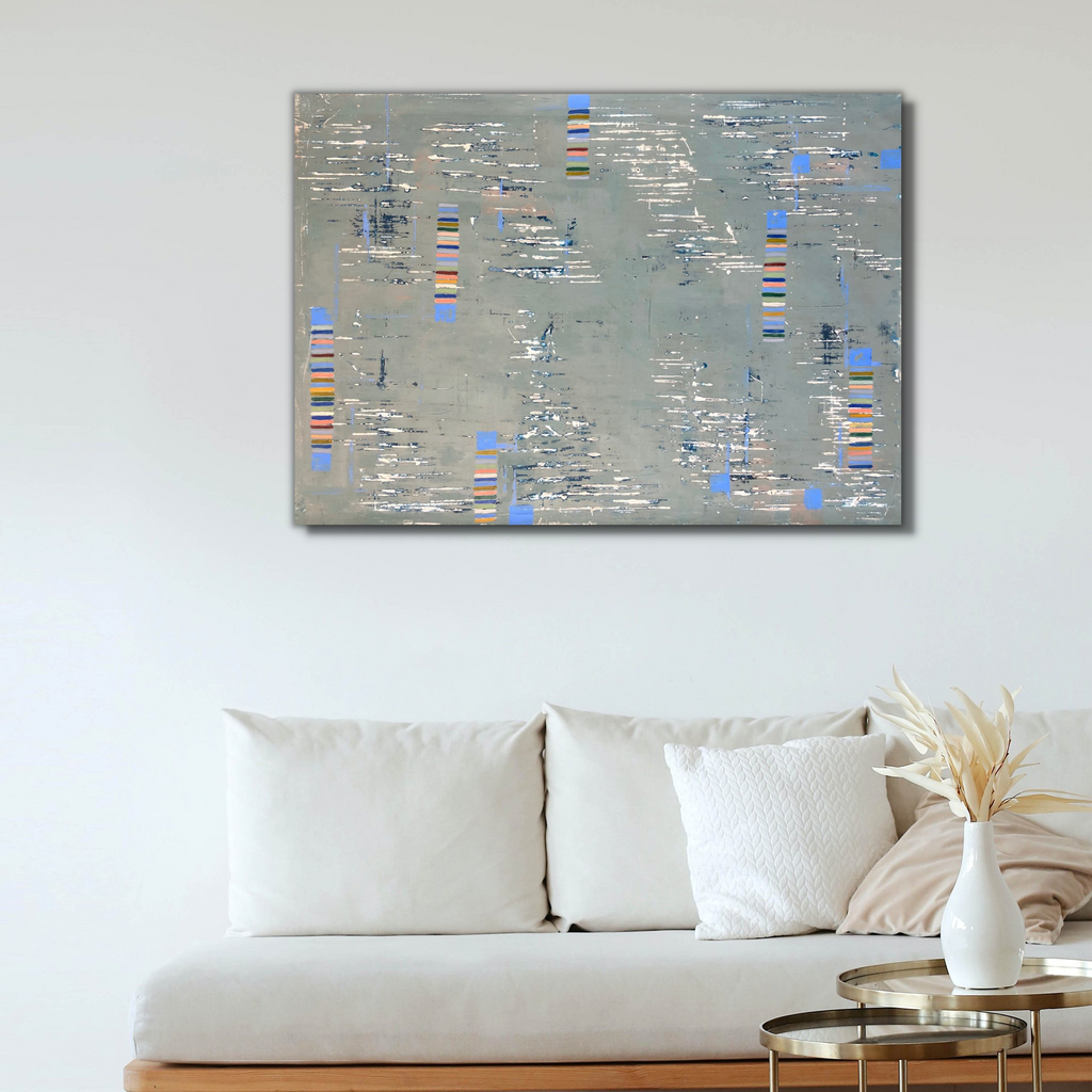 The artwork 'Sonata' by Shira Toren features a textured abstract composition in silvery grey Venetian plaster with scattered geometric blocks of blue and orange accents. The surface creates a rhythmic pattern reminiscent of a musical score, with layered plaster revealing subtle depth and dimension. The 36x48 inch canvas showcases a contemporary minimalist aesthetic with weathered, industrial-inspired textures.