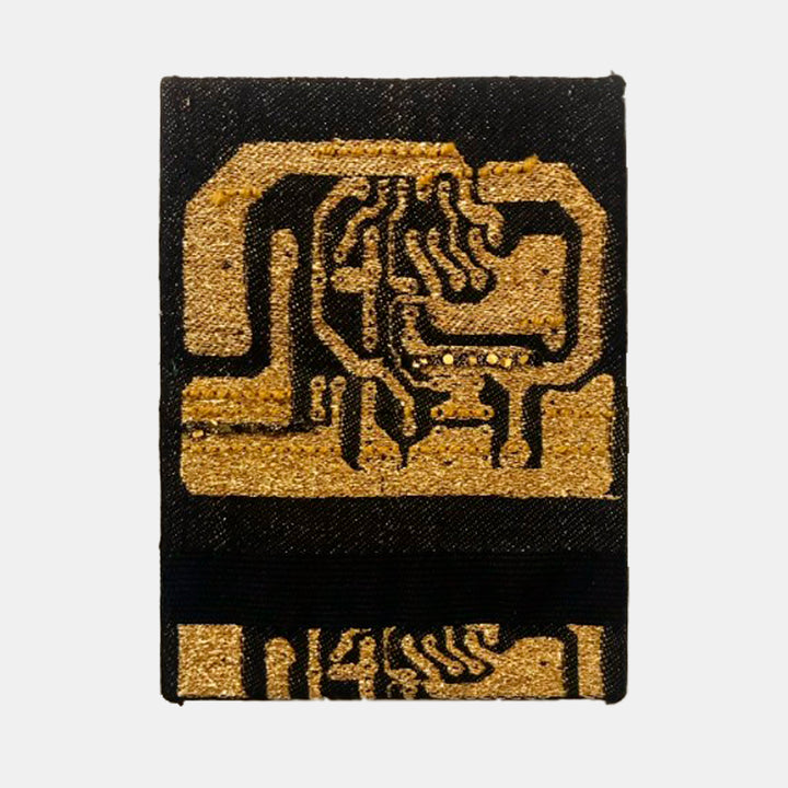 The artwork 'Source Code' by Robin Kang features a hand-jacquard woven design depicting abstract circuit board patterns in metallic gold yarn against a deep black cotton background. The geometric composition resembles electronic pathways and components, with curved lines and angular shapes creating a technical aesthetic, stretched on 8x6 inch canvas.