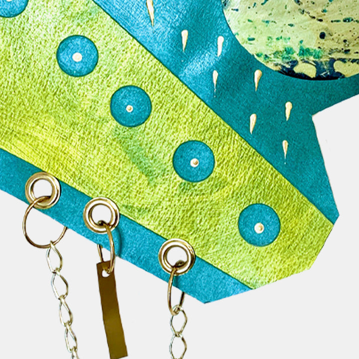 The artwork 'Space Shower' features vibrant geometric patterns in turquoise and lime green, with metallic chain embellishments. Abstract circular forms and diagonal lines create a dynamic composition. The acrylic painting on paper showcases playful dots and droplet-like shapes, combining modern design with cosmic elements. Artwork by Sunny Chapman.