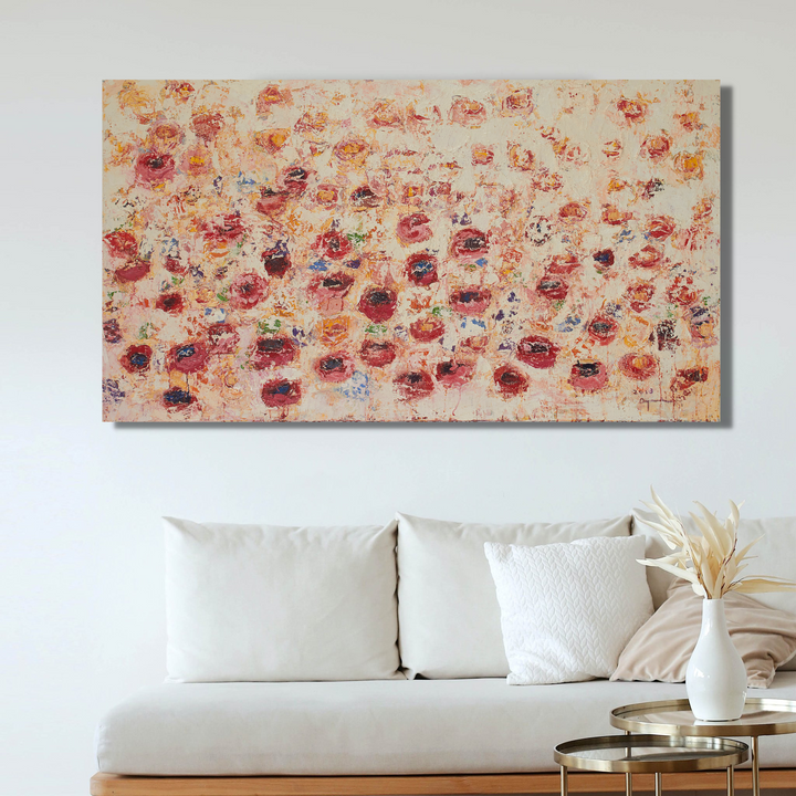 The artwork 'Spring Wants to Say Something' by Ayane Kurai features a mesmerizing field of abstract coral and pink florals scattered across a cream-colored canvas. The impressionistic brushstrokes create delicate, layered petals in varying shades of salmon, burgundy, and peach, suggesting a dreamy spring garden in full bloom. Oil on canvas, 36x65 inches, creating a stunning focal point above a modern white sofa.
