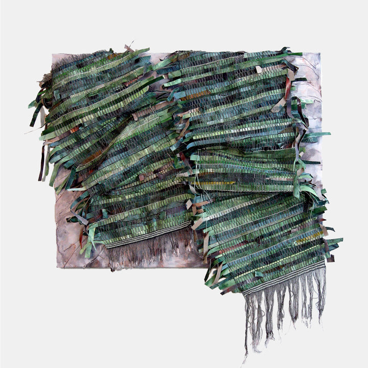 The artwork 'Stripes Earned' by Christina Massey features layered strips of green and turquoise textiles creating diagonal patterns across the canvas. Interwoven yarn and fabric elements add dynamic texture, while acrylic paint creates a subtle metallic sheen. The composition flows with organic movement, combining mixed media techniques on canvas and linen.