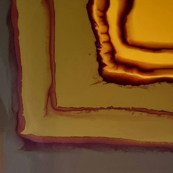 The artwork 'Study 165' by Sabrina Puppin features abstract layered shapes in rich amber and burgundy tones, creating a dimensional effect through synthetic glazes on wood. The composition shows concentric angular forms with textured edges, resembling topographic contours in warm earth colors, measuring 12x12 inches.
