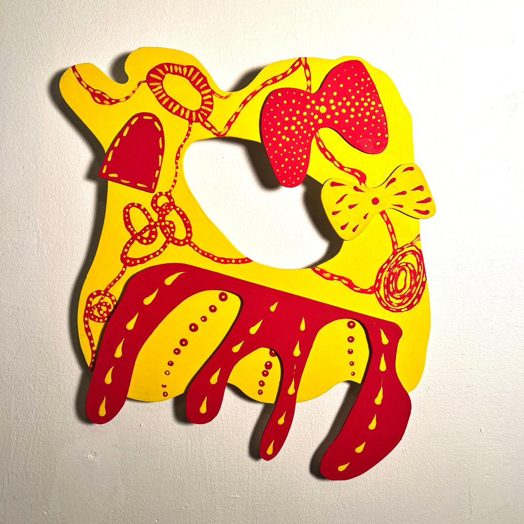 The artwork 'Buddhist Rodeo' features a vibrant yellow background with bold red abstract designs. The piece depicts a stylized animal form with decorative patterns, dots, and swirling lines. The matte acrylic on wood creates a striking contrast between the warm colors and geometric shapes. The 12x12 inch contemporary art piece demonstrates a playful fusion of Buddhist symbolism and western motifs by Sunny Chapman.