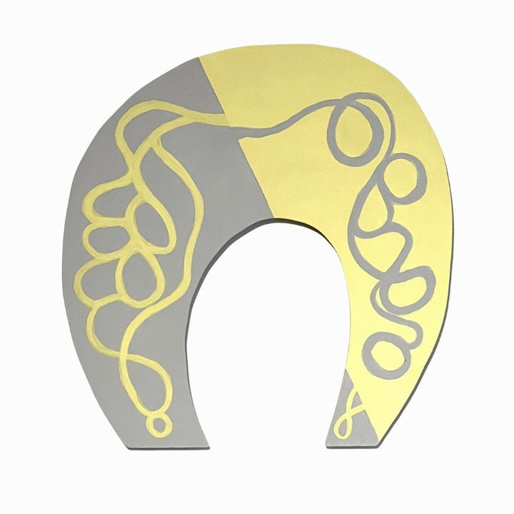The artwork 'Folderol' by Sunny Chapman features a horseshoe-shaped design with flowing, curvilinear patterns in matte acrylic. Split diagonally, the piece combines soft yellow and gray tones, with elegant swirling lines creating a symmetrical, abstract composition. The 11x11 inch artwork demonstrates a modern, minimalist approach with organic, decorative elements.