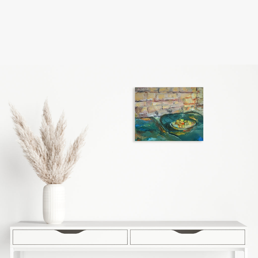 The artwork 'Tangerines' by Rita BasuMallick features fresh citrus fruits nestled in a turquoise ceramic bowl, set against a textured brick wall background. The oil painting employs bold brushstrokes to capture the warm orange hues of the fruit contrasting with cool teal tones, creating a striking still life composition on an 11x14 inch canvas.