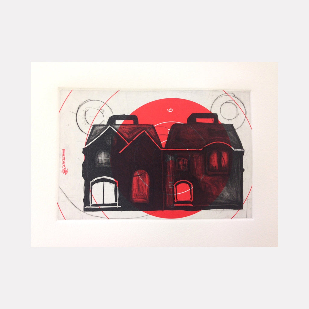 The artwork 'Targetted' by Margaret Roleke features a monochromatic house silhouette in black against a white background, with a striking red circular shape behind it. The etching and collage technique creates a haunting architectural study with geometric circles and crosshair-like markings overlaying the composition. The house's windows glow with an ominous red light, suggesting both warmth and warning.