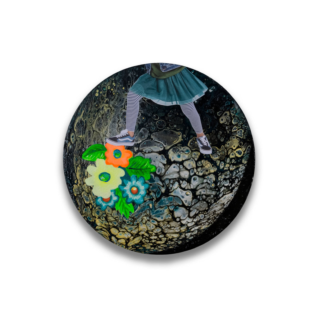 The artwork 'The Girl Who Chased the Moon' shows striped legs in vintage-style socks and shoes against a dark, textured background with vibrant collaged flowers in turquoise, orange, and green. The circular 10x10 inch composition combines acrylic painting with mixed media elements on wood panel, creating a whimsical and mysterious atmosphere. By Mary Younkin.