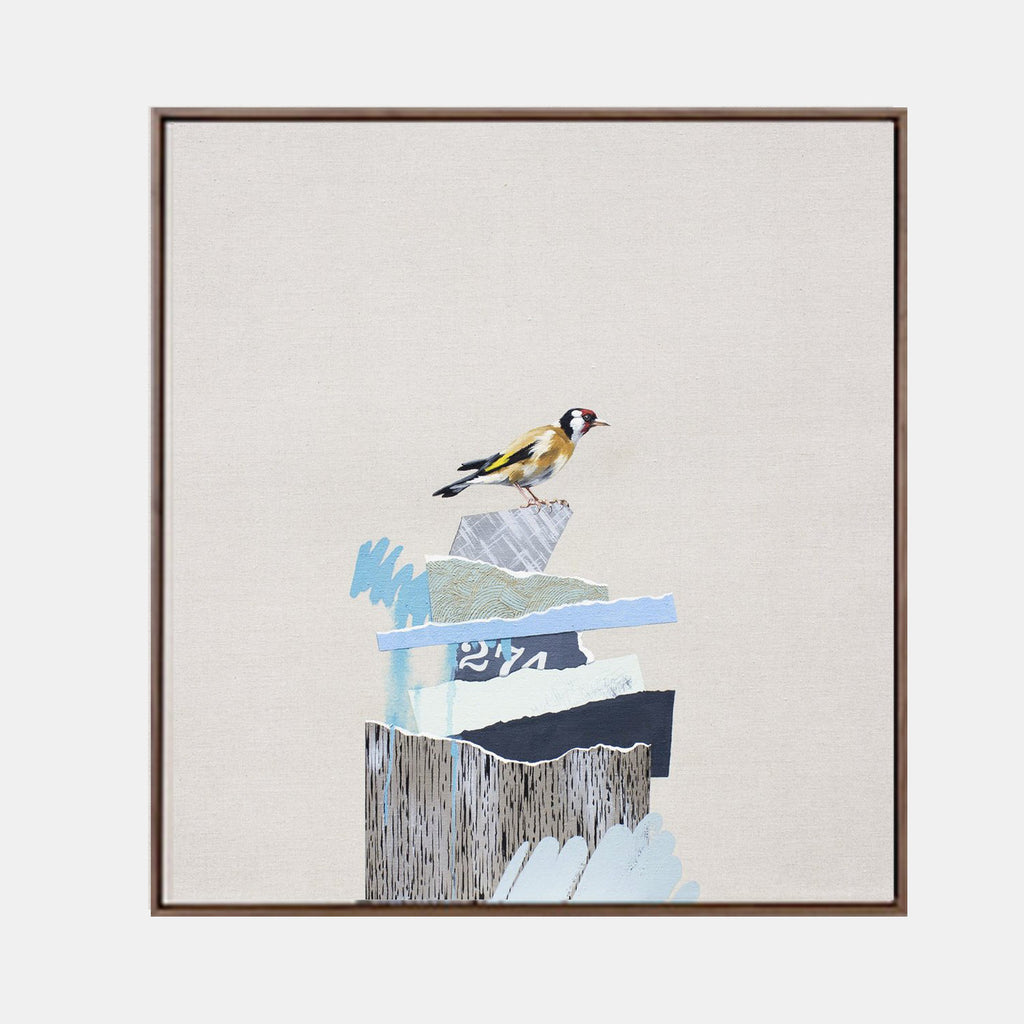The artwork 'The Rise and Fall No.16' by Lauren Matsumoto features a delicate goldfinch perched atop an abstract composition of layered geometric shapes in soft blues, grays, and textured woodgrain patterns. Oil on linen canvas showcases a minimalist aesthetic with careful attention to ornithological detail against a serene cream background, framed in walnut.