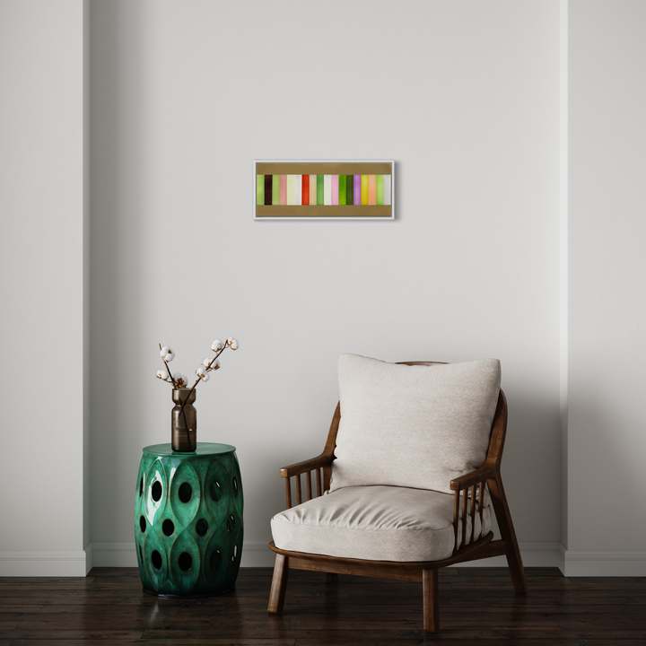 The artwork 'Each of the colors of spring cocooned by all of the colors of spring' by Debra Ramsay features vertical rectangular stripes in green, orange, white, and yellow tones arranged horizontally in a minimalist composition. Acrylic on polyester resin film in a silver frame, creating a modern abstract representation of spring colors. 9x24 inches.