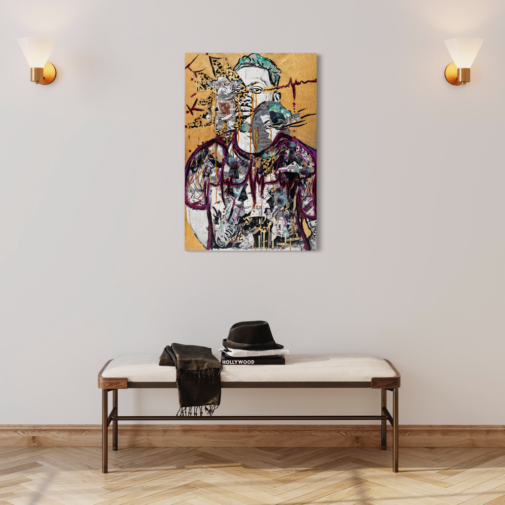 The artwork 'Heartbeat of Fatherhood' by Courtney Minor features an abstract collage portrait on canvas set against a warm golden background. Dynamic black linework and splashes of vibrant colors create a modern, expressive composition. The mixed-media piece combines graffiti-style elements with traditional portraiture, displayed above a minimalist bench with wall sconces on either side.