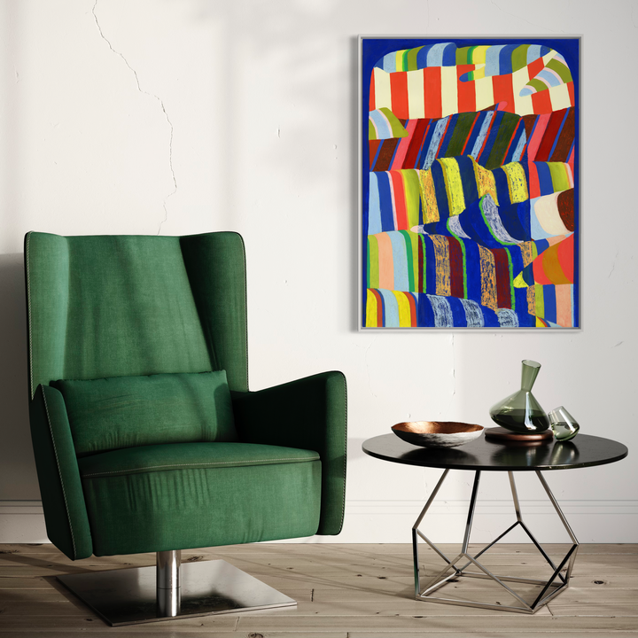 The artwork 'Blue Arch' by Natalie Lanese features vibrant striped patterns undulating across the canvas in a dynamic wave formation. Bold red, blue, yellow, and green stripes create a rhythmic, abstract composition against a deep blue background. Mixed media technique combines acrylic and DayGlo paint, creating a striking visual effect displayed above an emerald green armchair.