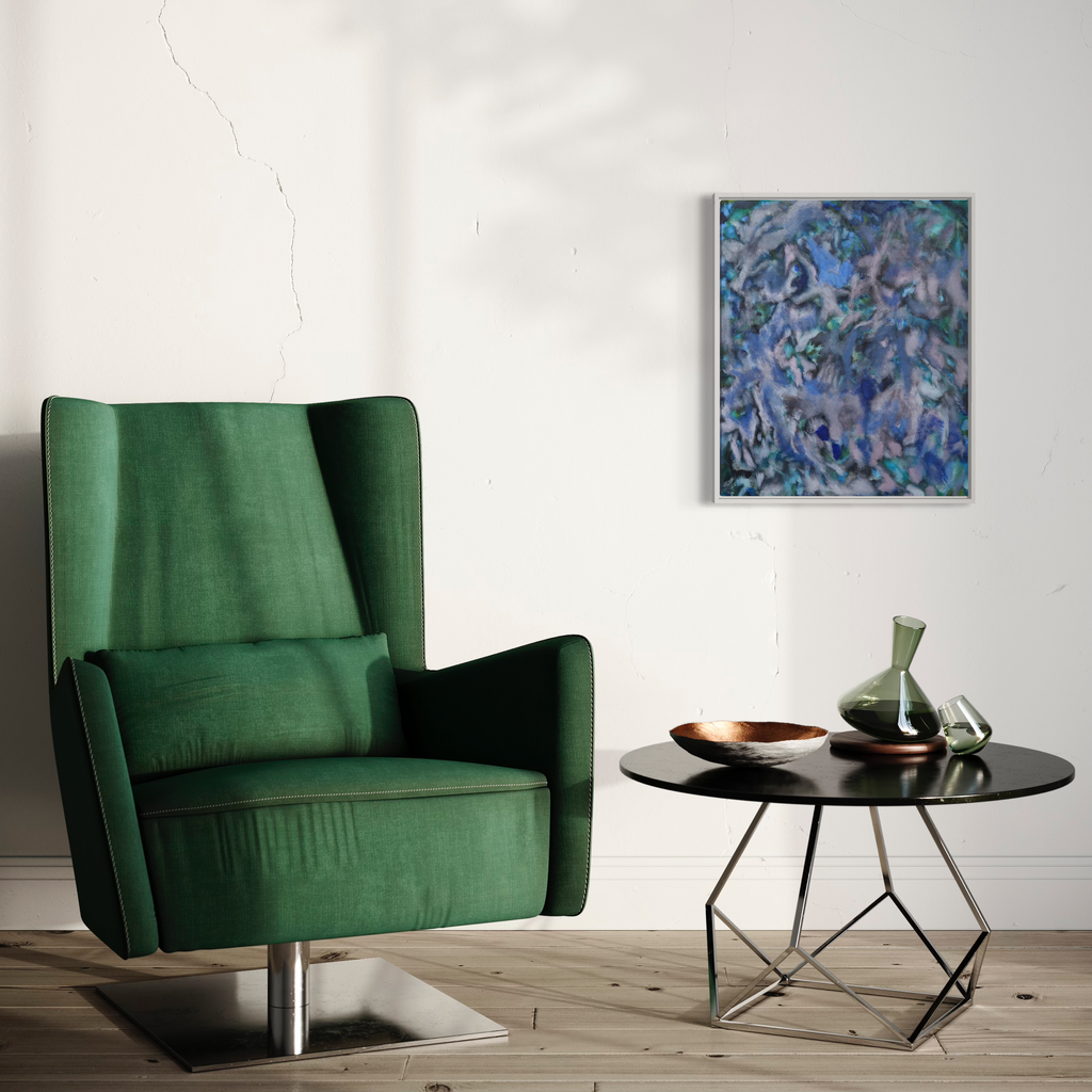The artwork 'Depths' by Diana Naccarato features abstract swirling patterns in shades of blue, turquoise, and purple, displayed in a modern interior setting with a emerald green velvet armchair and black geometric side table. The acrylic and charcoal artwork is framed, measuring 24x20 inches, showcasing fluid, aquatic-inspired movements and textures.